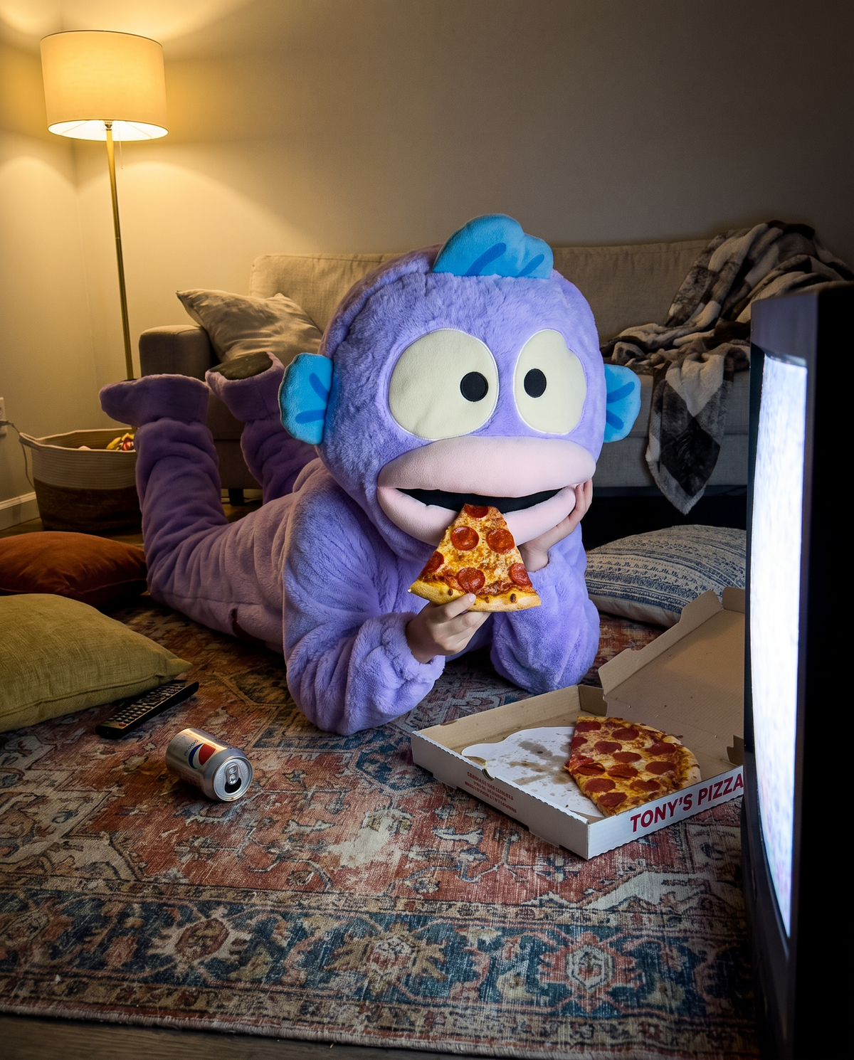 CosyBoo pyjama violet : allongé sur le tapis devant la télé avec une part de pizza